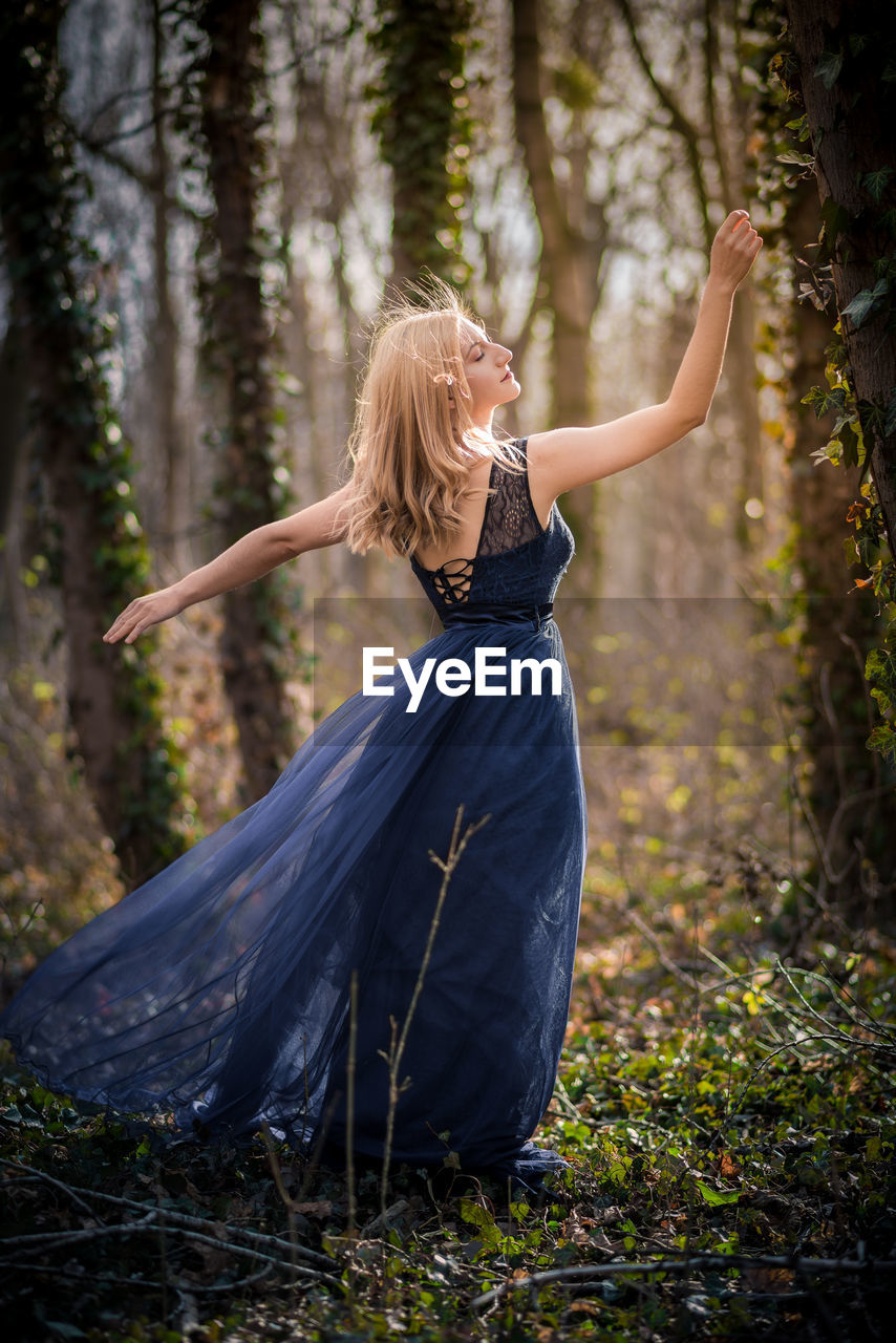 Rear view of female model posing in forest