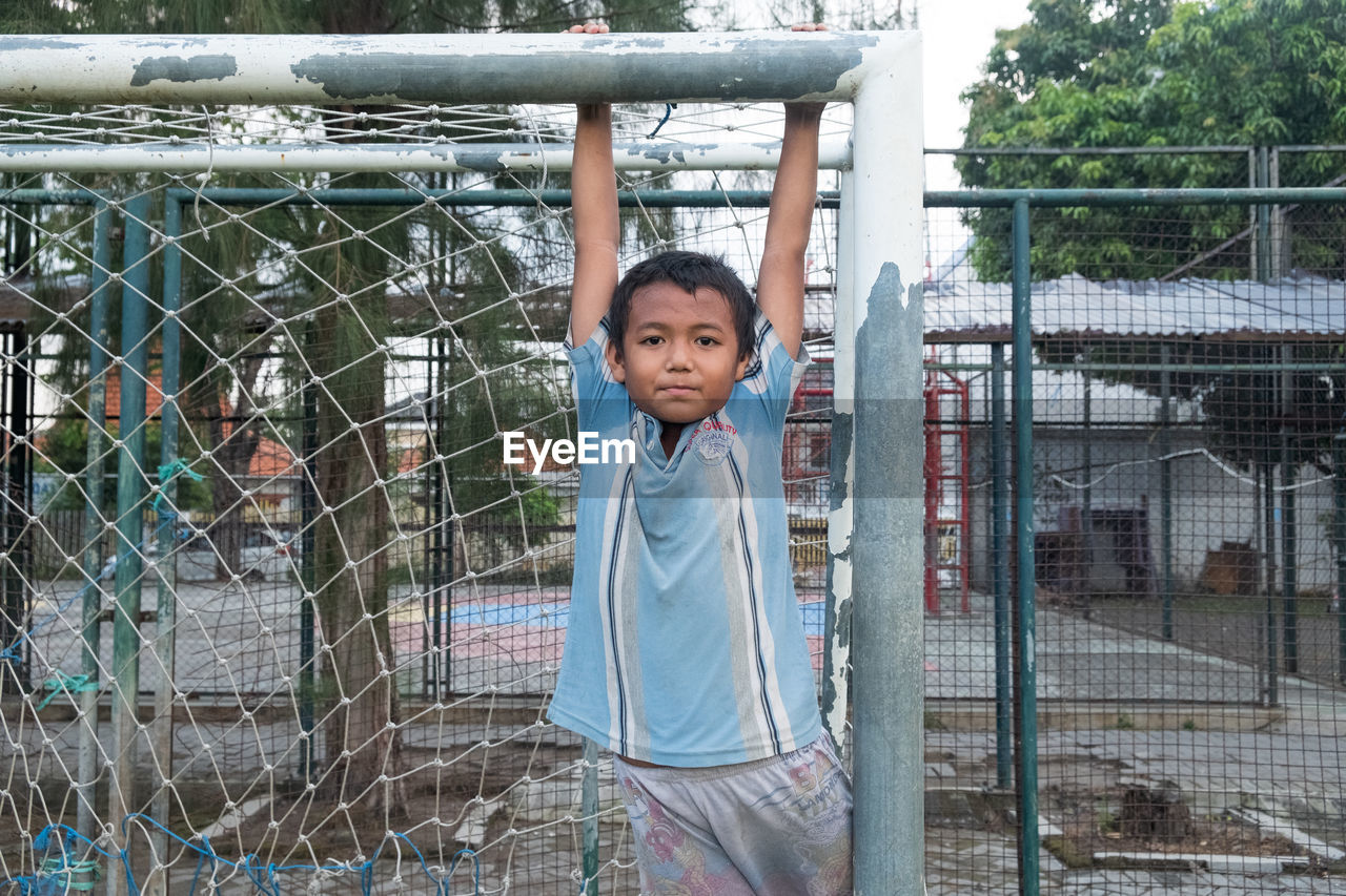 Portrait of boy hanging on railing