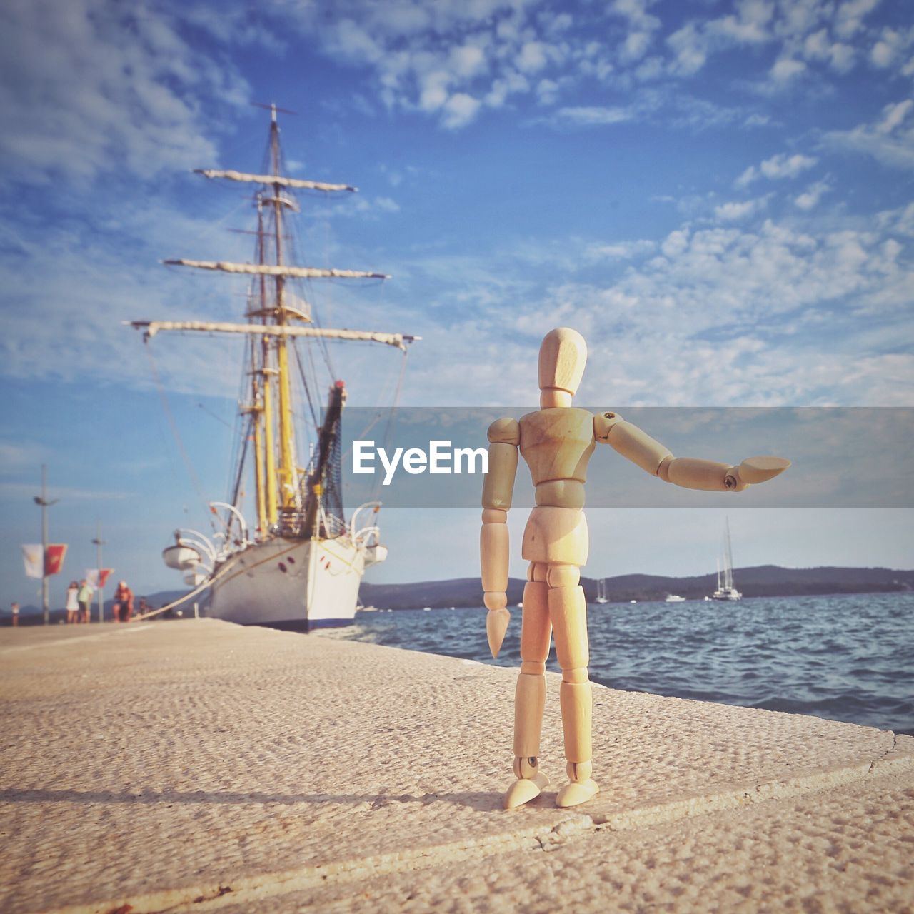 WOMAN STANDING ON BOAT AGAINST SKY