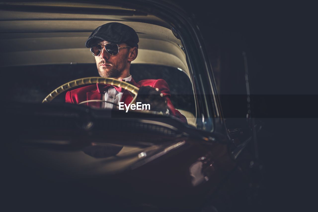 Man driving vintage car at night