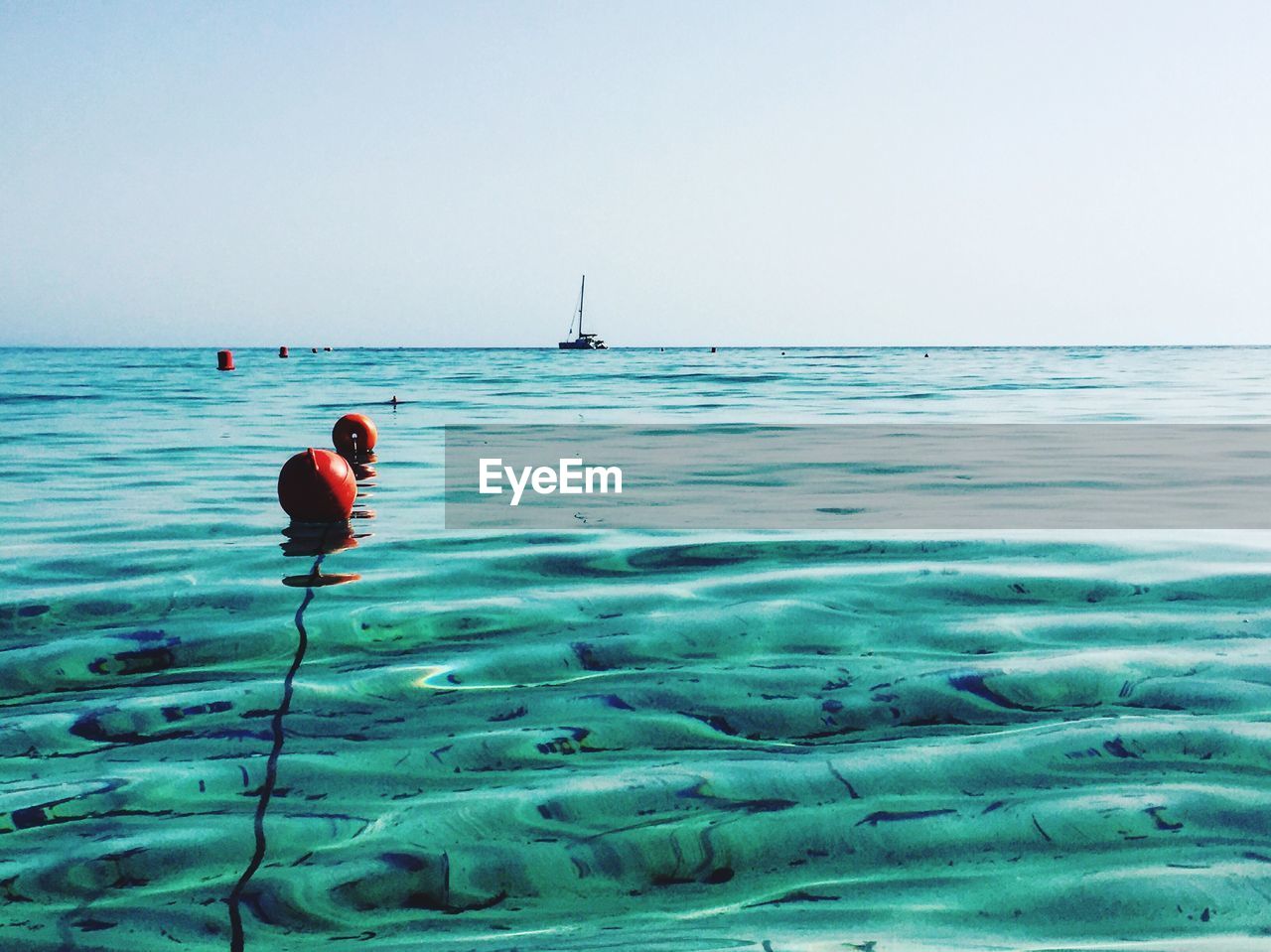 Buoys floating at sea against sky