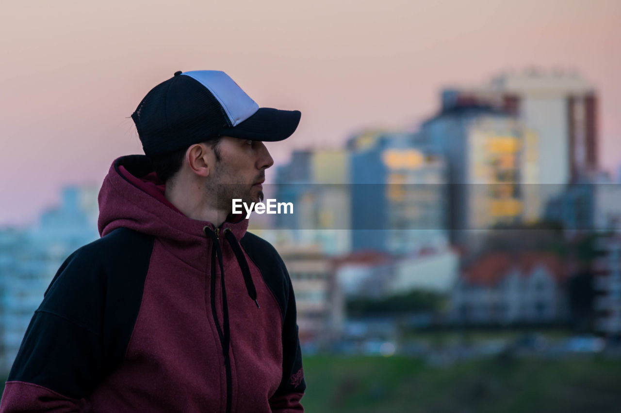 Man looking at cityscape during sunset