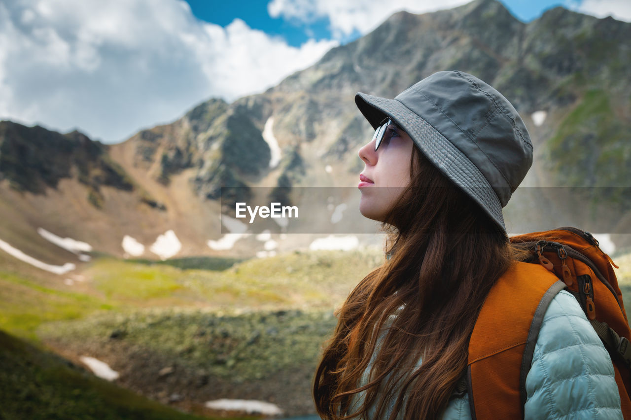 Side view portrait of a woman standing and breathing fresh air in the mountains. profile of a female