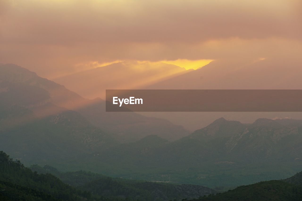 SCENIC VIEW OF MOUNTAIN AGAINST SKY DURING SUNSET