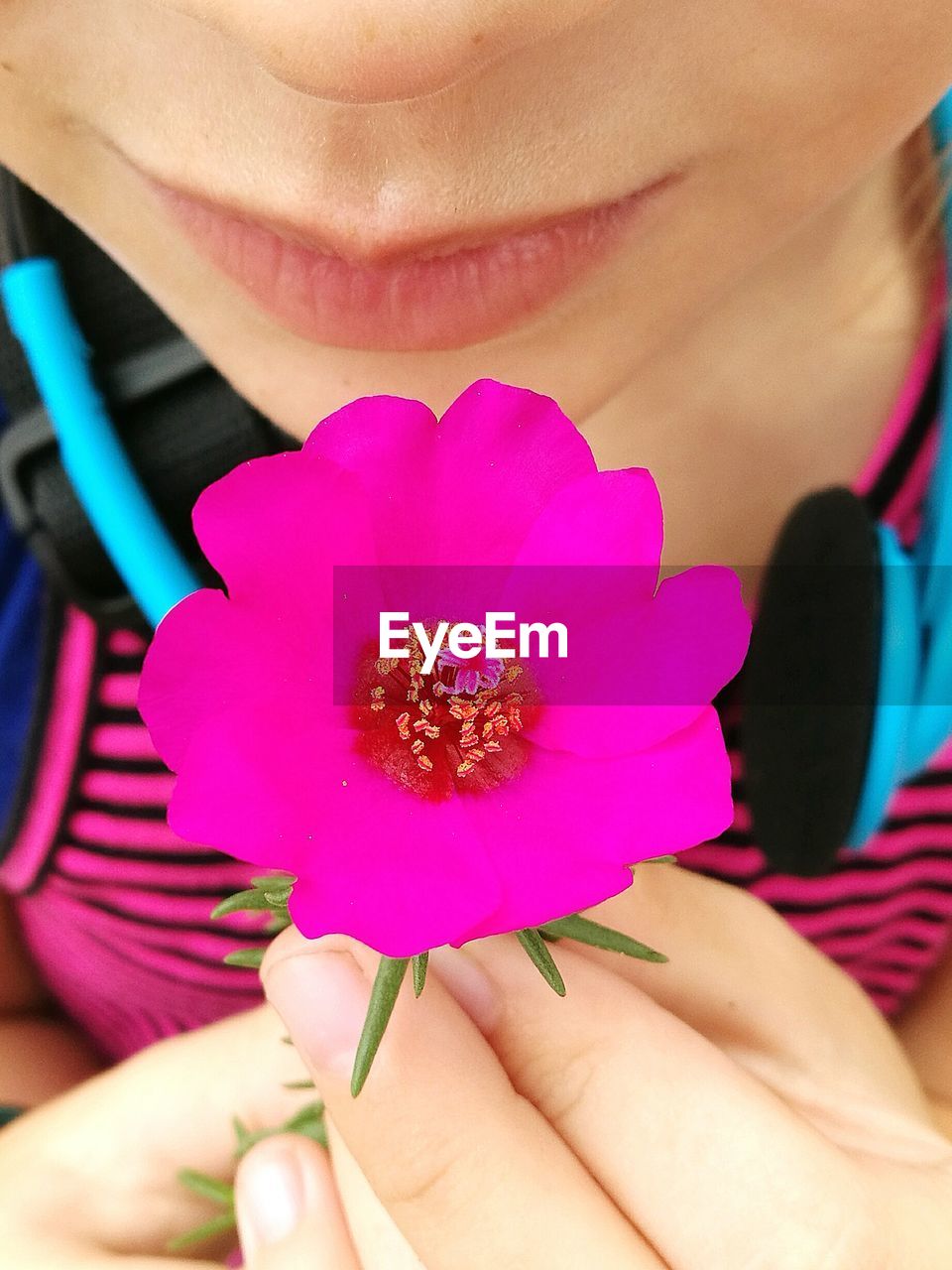 Midsection of woman holding pink flower