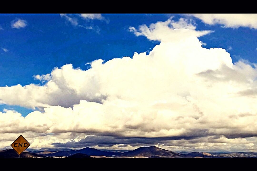 SCENIC VIEW OF MOUNTAINS AGAINST CLOUDY SKY