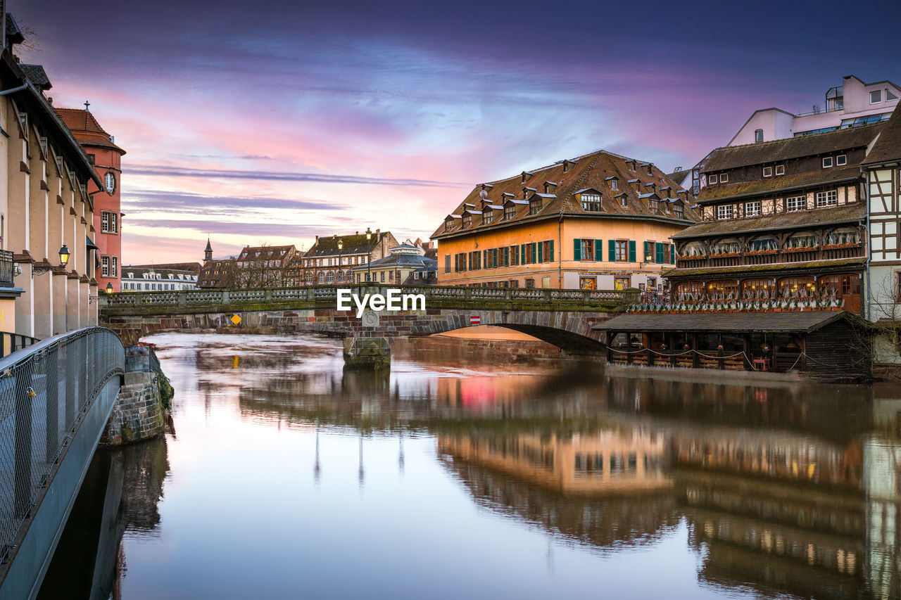 Le petite france, river flowing through the strasbourg city next to tall buildings