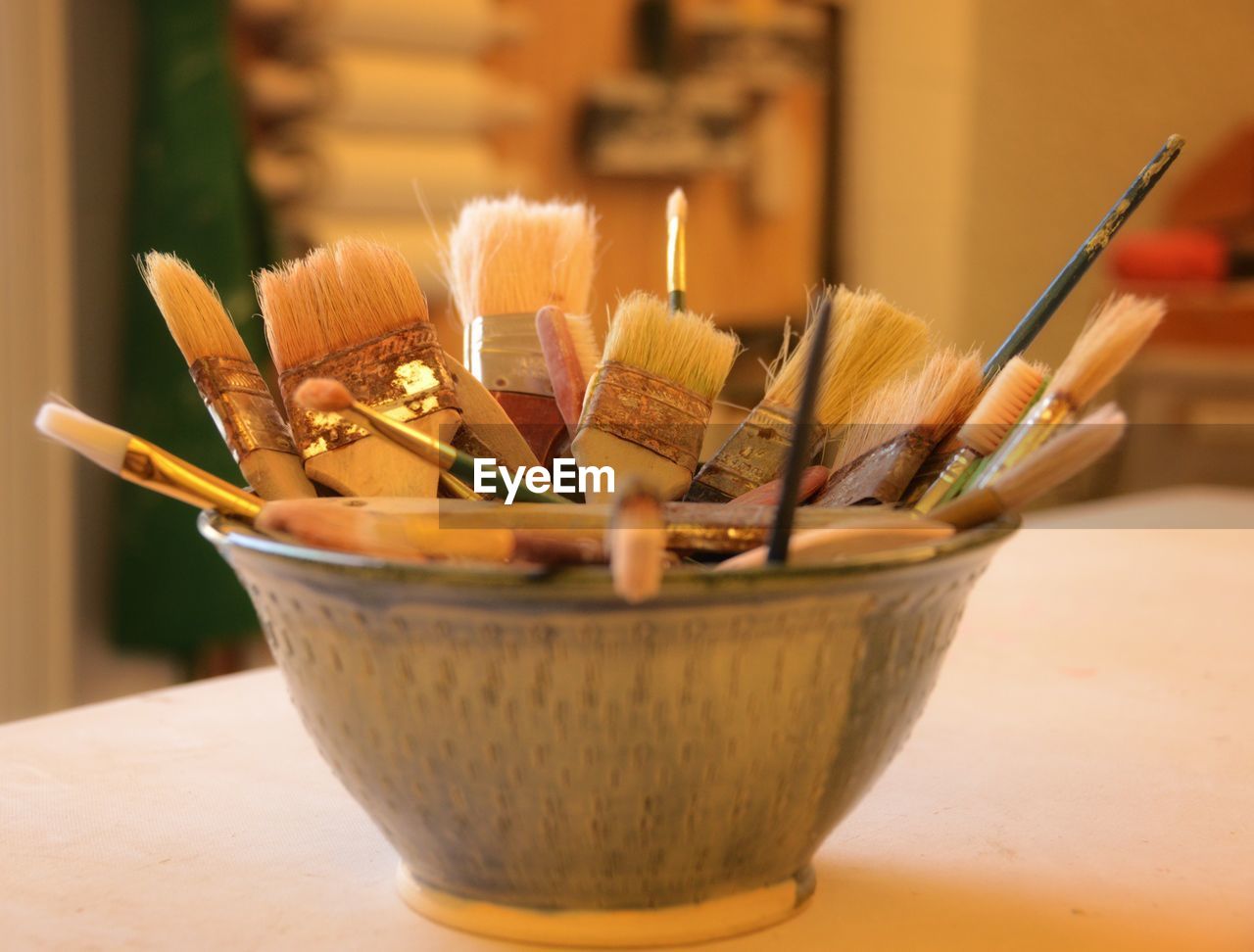 Paintbrushes in container on table