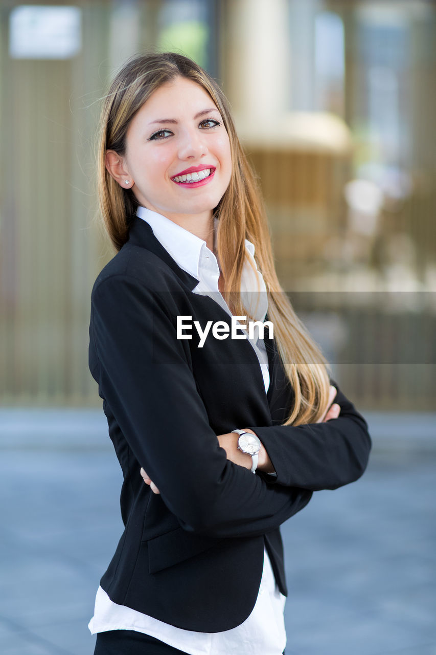 Portrait of young businesswoman standing in city