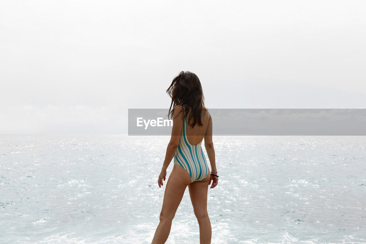 Side view of woman standing at beach