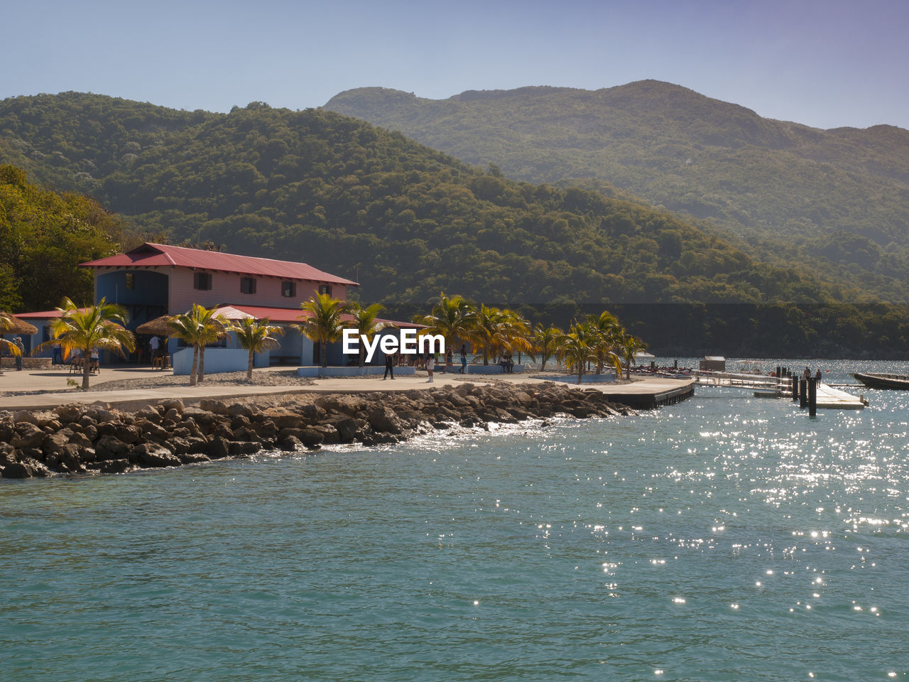 View of houses by sea against mountain range