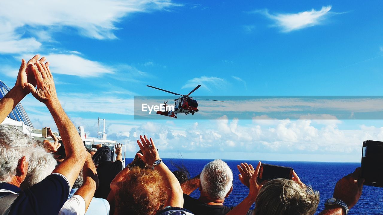 PEOPLE PHOTOGRAPHING BOATS IN SEA