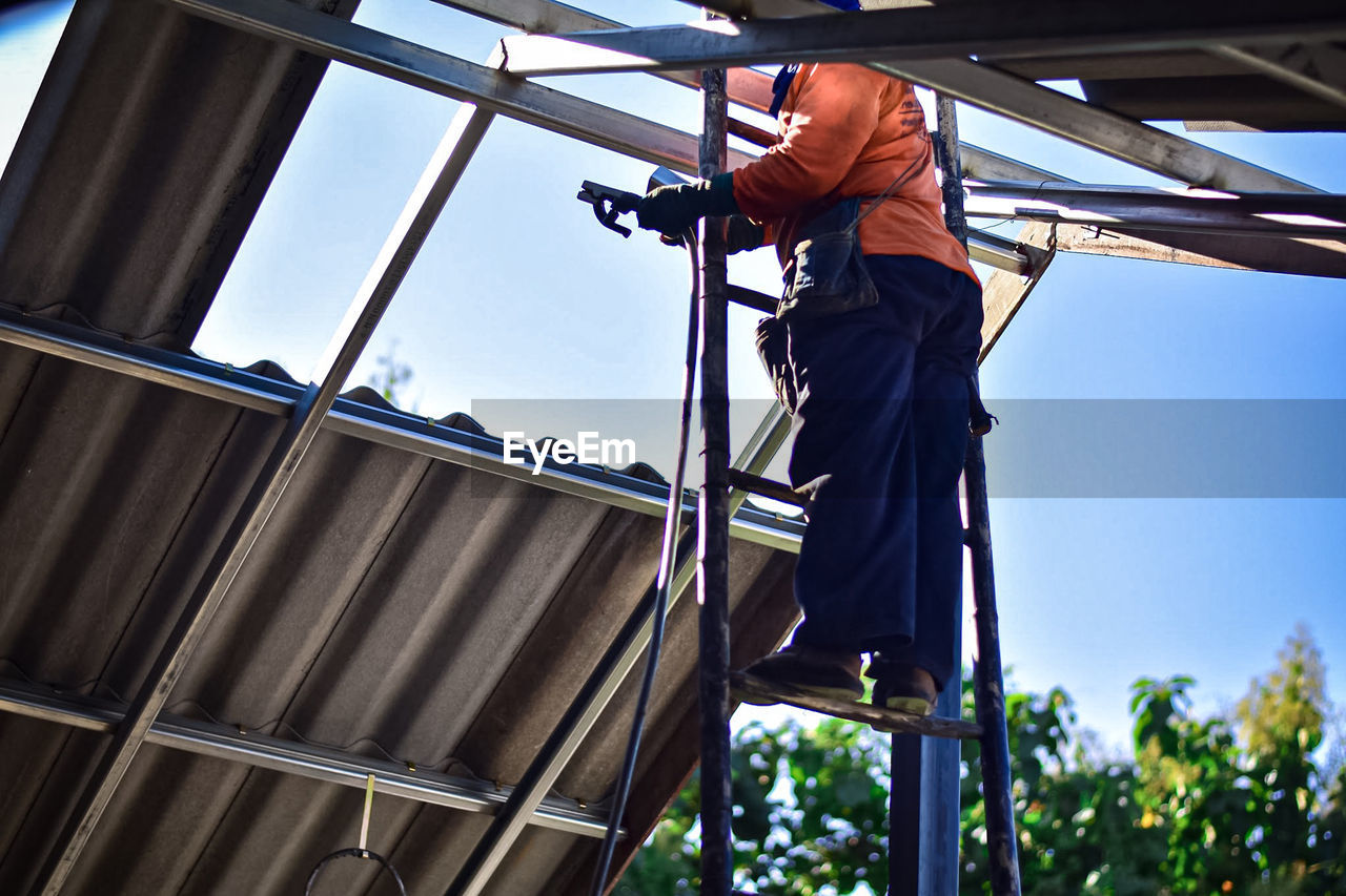 Low angle view of man working at construction site