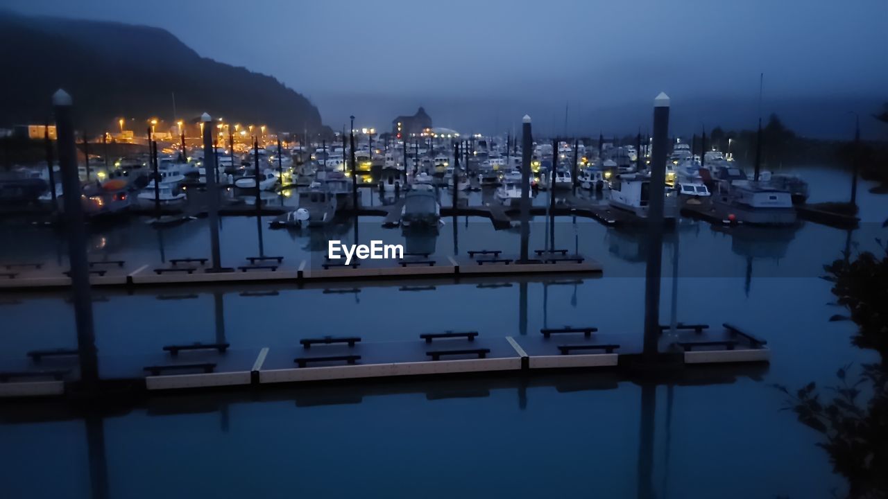 water, reflection, marina, dock, nautical vessel, night, transportation, architecture, sky, harbor, nature, evening, dusk, illuminated, moored, twilight, mode of transportation, no people, sea, city, building exterior, pier, travel destinations, built structure, ship, beauty in nature, outdoors, cityscape, tranquility, vehicle, travel, scenics - nature, building, mountain