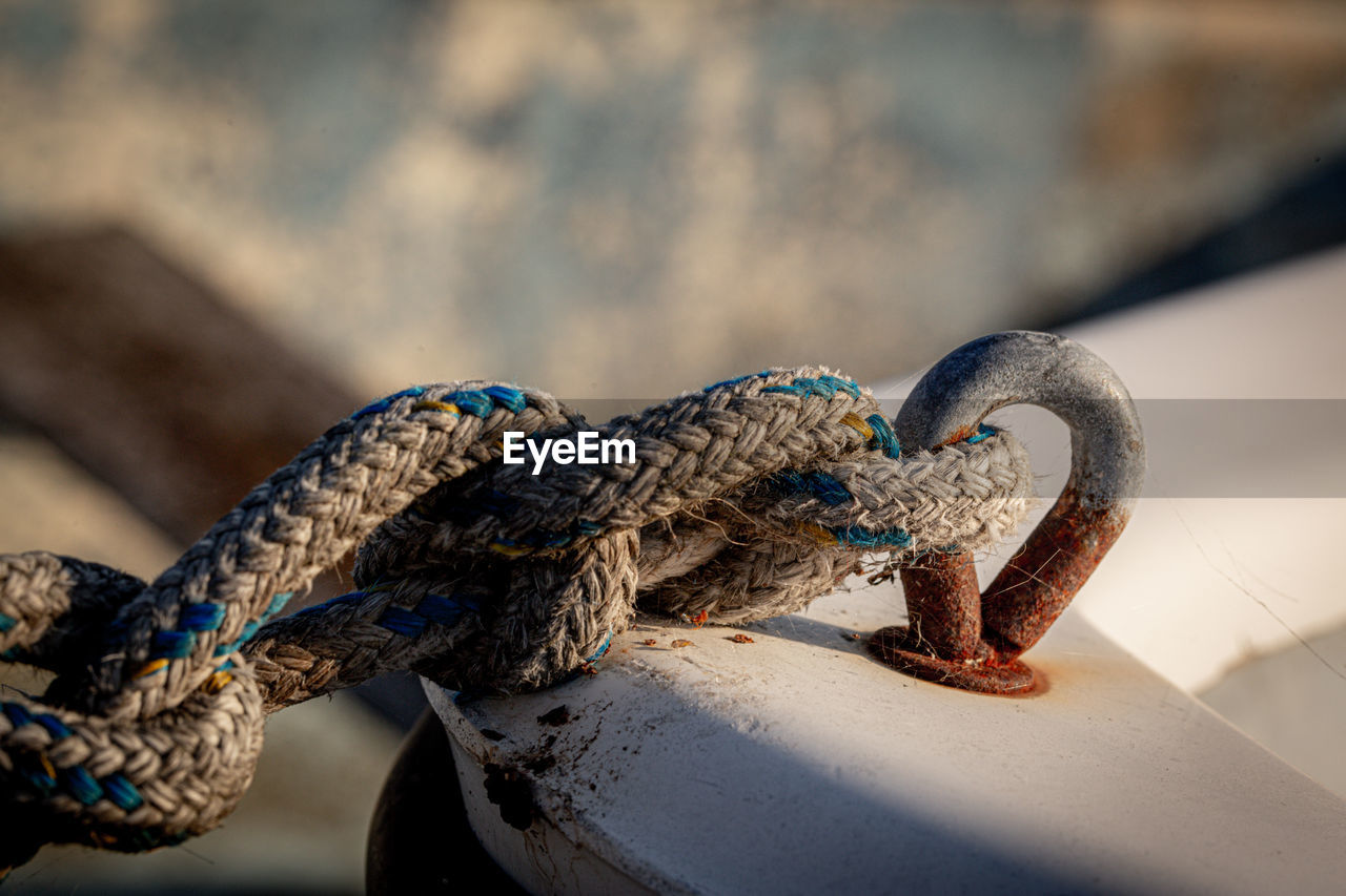 Close-up of boat ropes tied to a wooden boat 