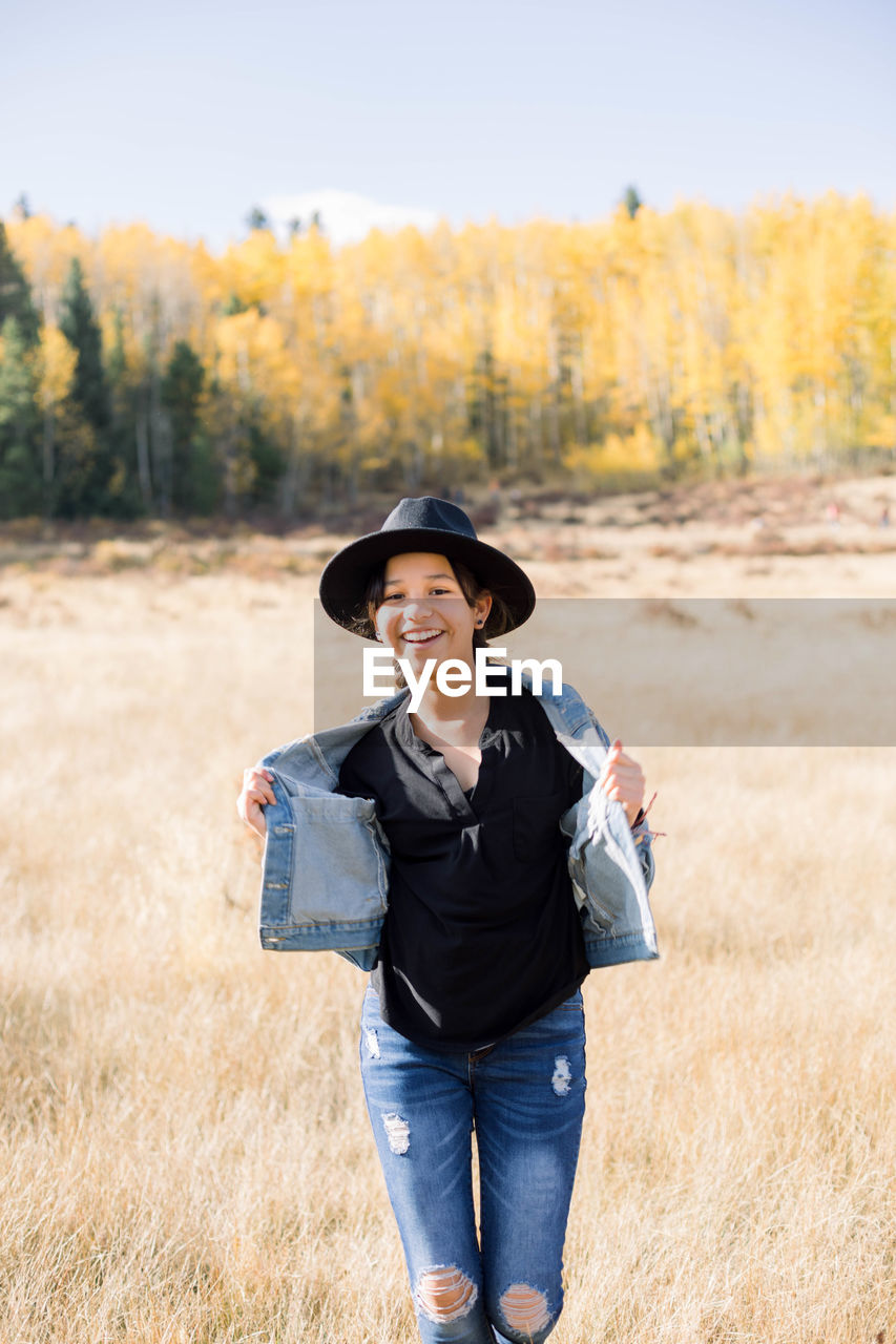 Young woman wearing hat standing on field