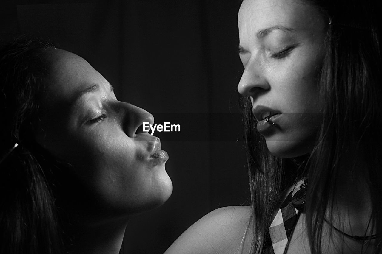 Multiple image of young woman with closed eyes against black background