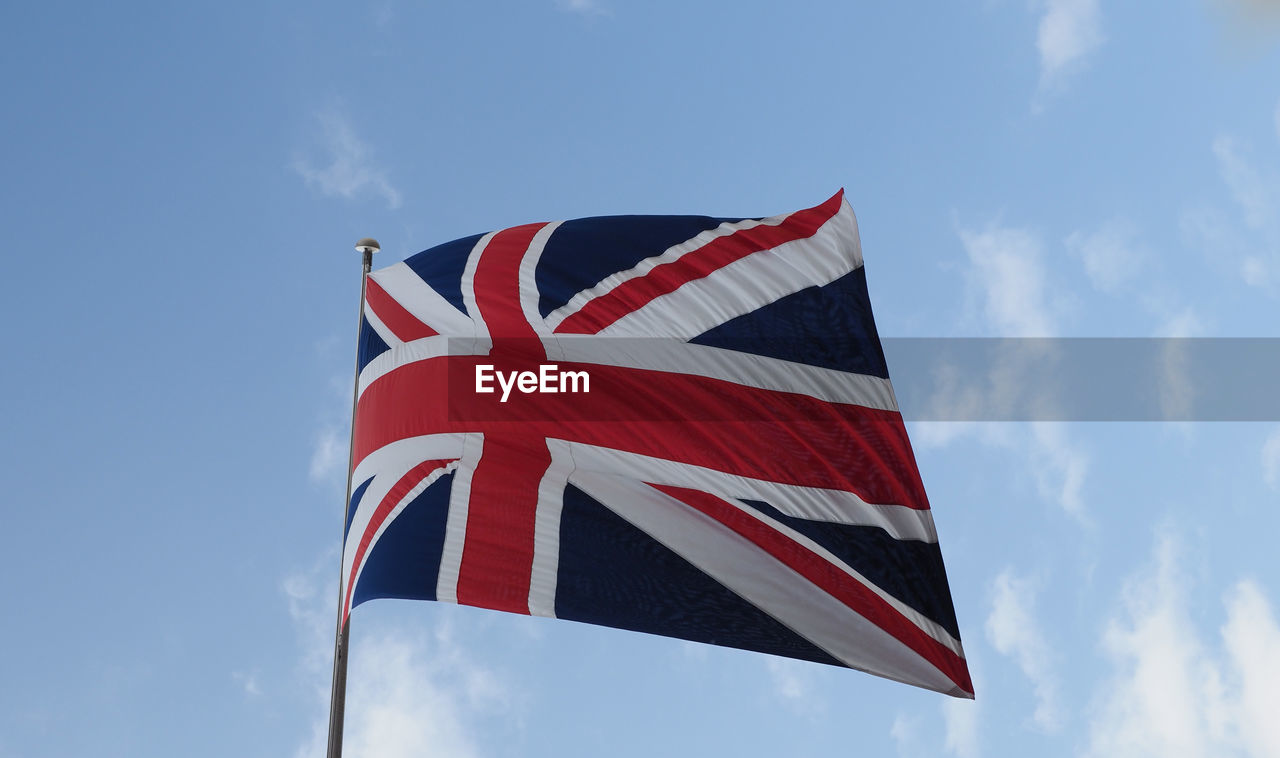 low angle view of flag against cloudy sky