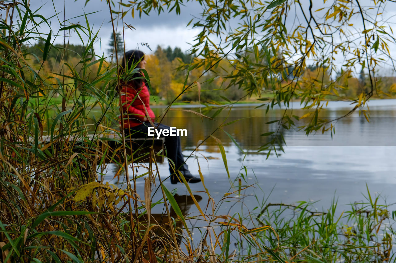 Reflection of person in lake against sky