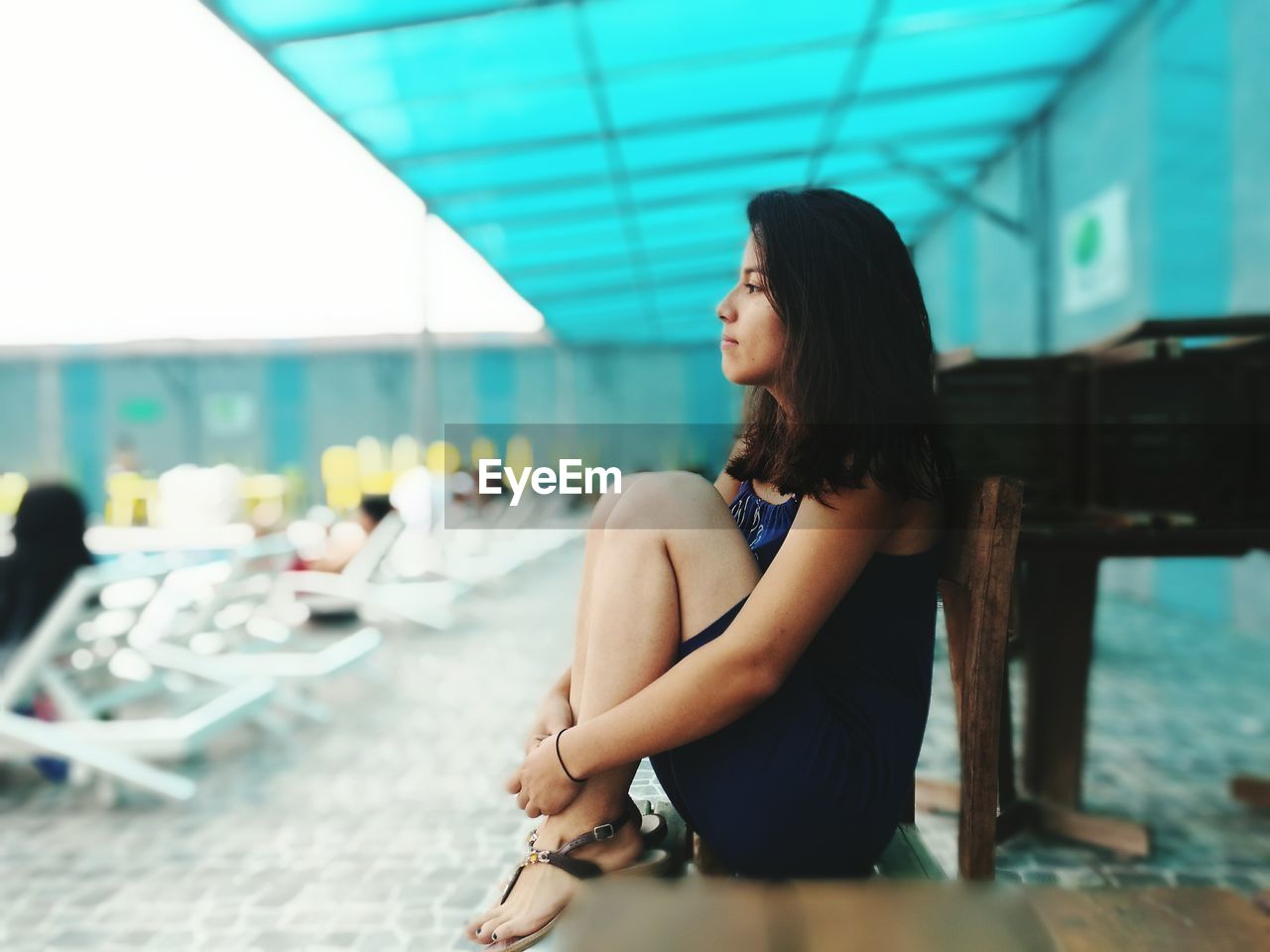 Side view of young woman sitting at resort