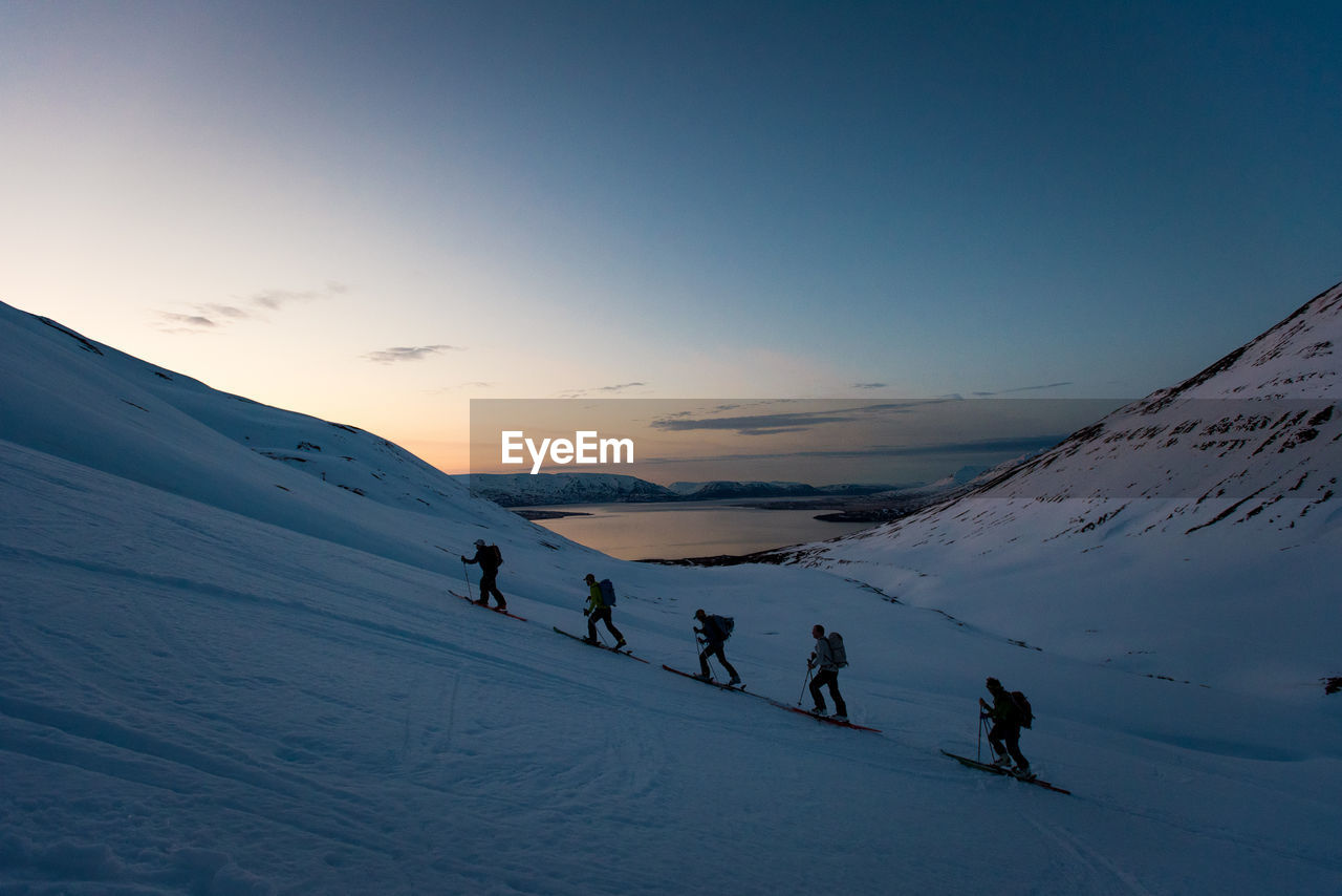 Group ski touring in iceland during sunrise