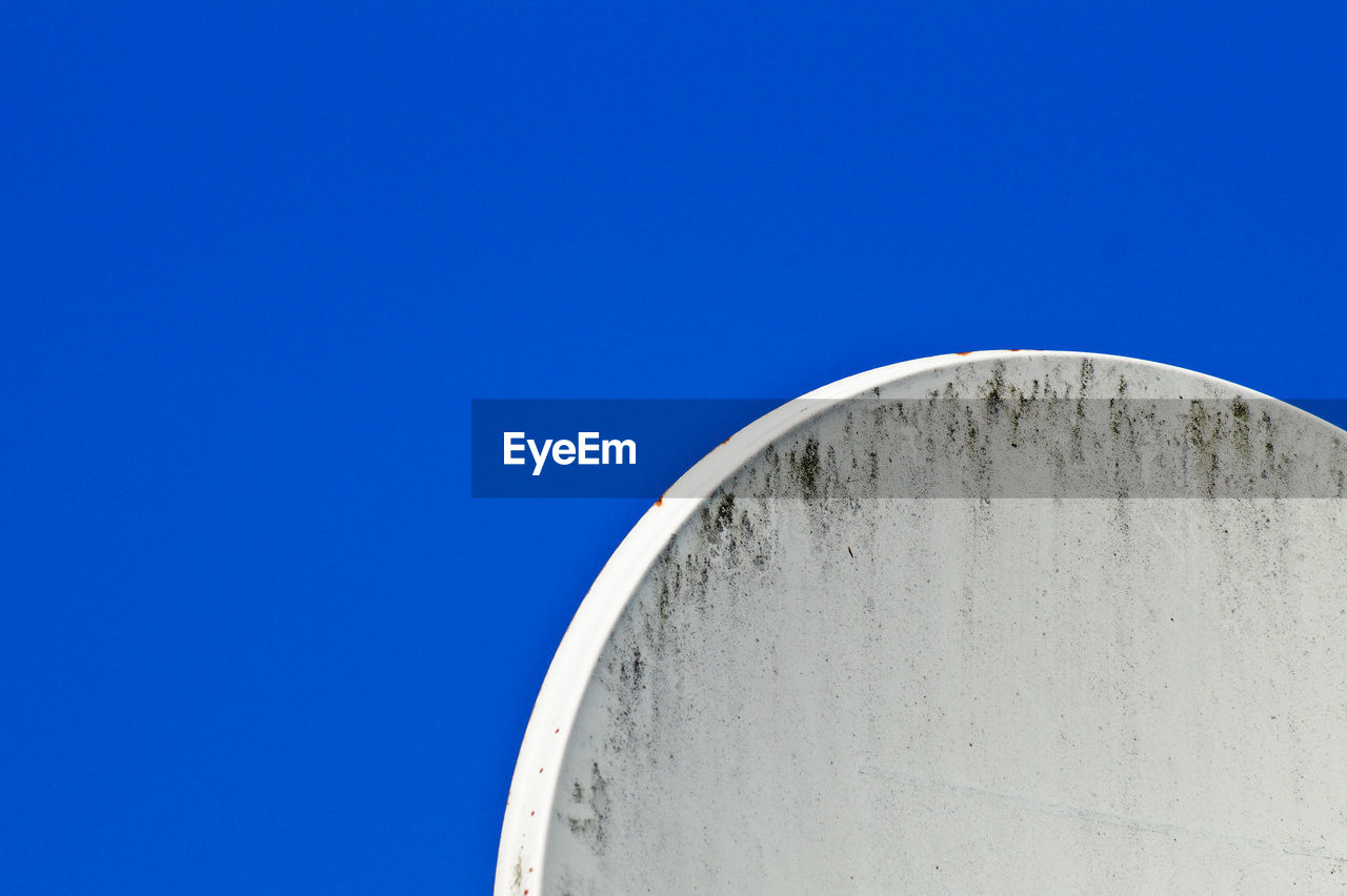 Cropped image of satellite dish against clear blue sky