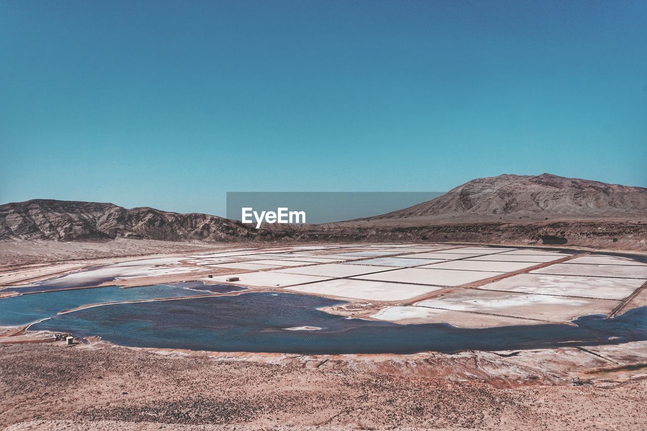 Scenic view of desert against clear blue sky