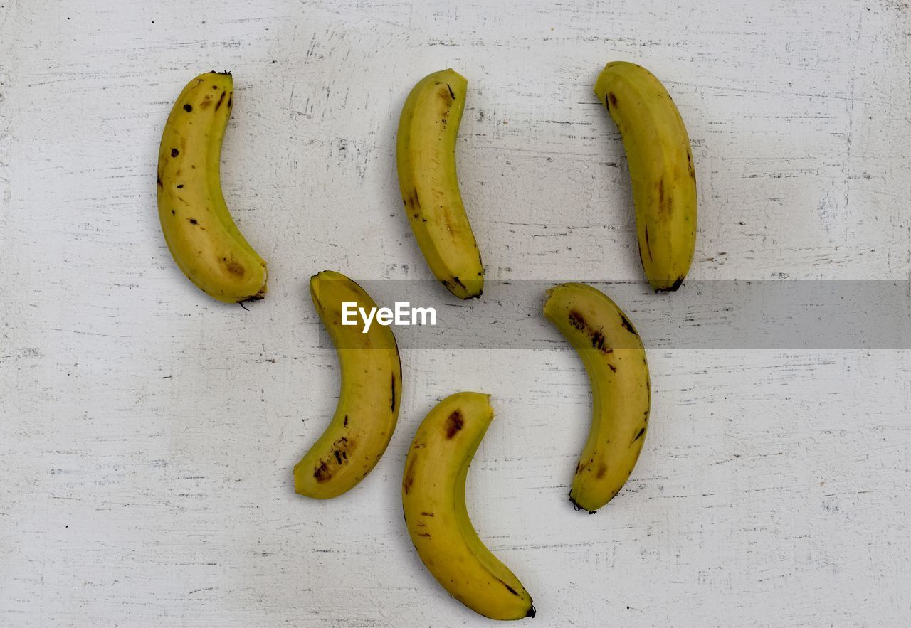 HIGH ANGLE VIEW OF BANANAS ON WHITE TABLE