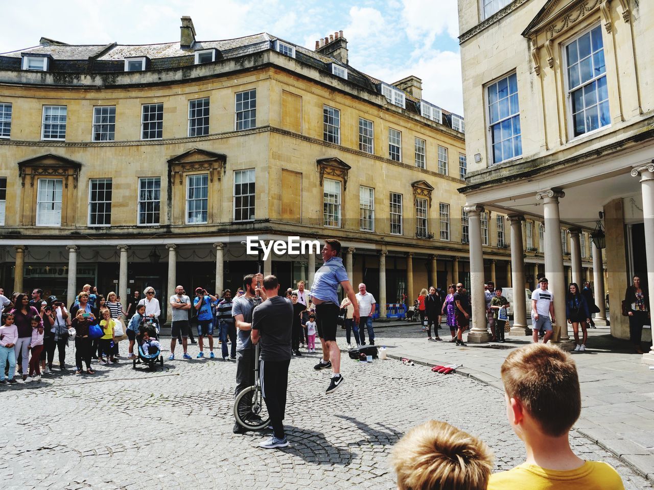 PEOPLE ON STREET AGAINST BUILDINGS