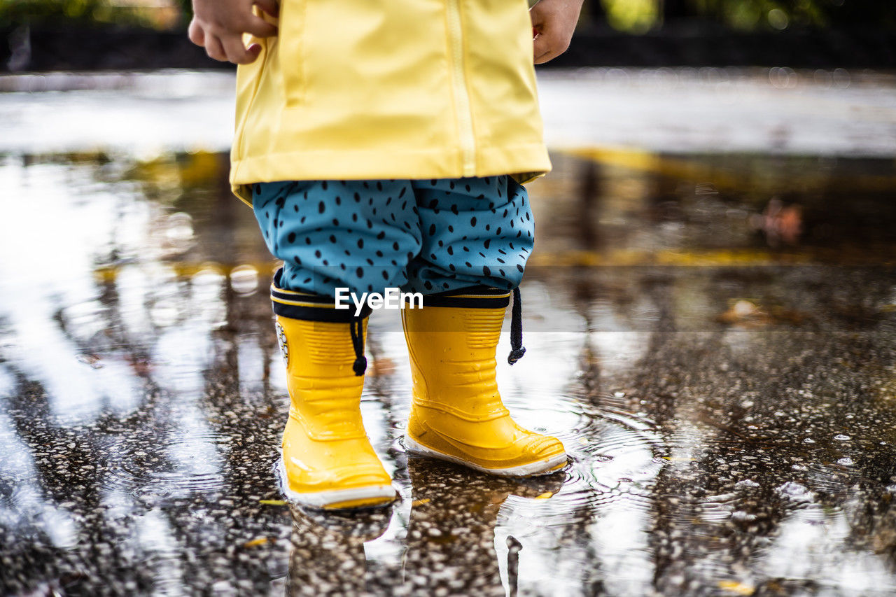 low section of man standing on puddle