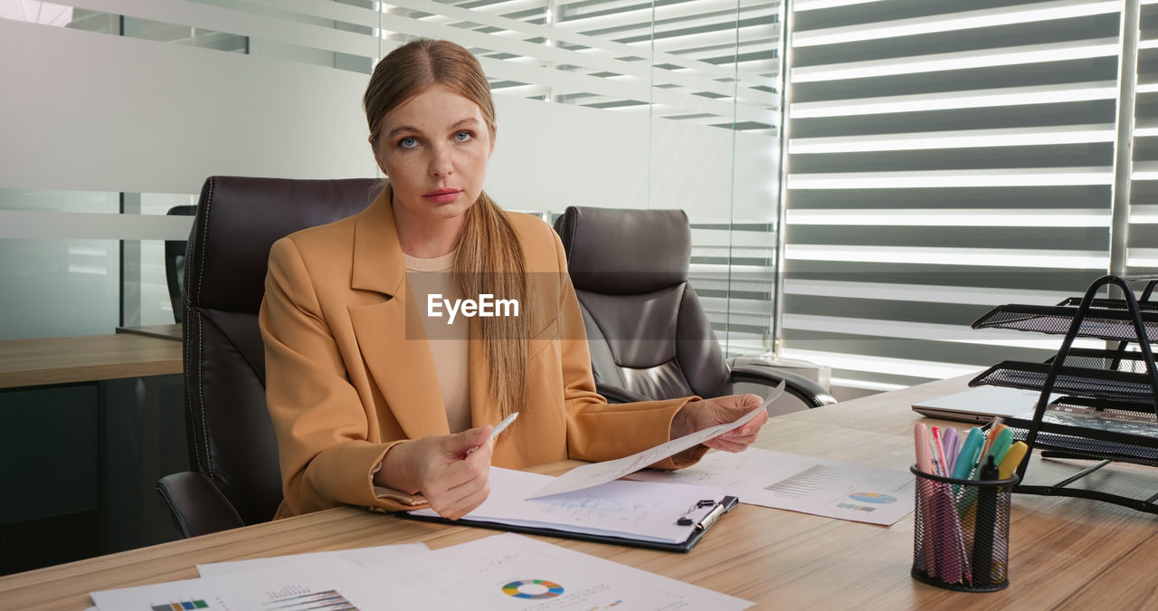 Businesswoman talking on video call conference in office looking at camera. 