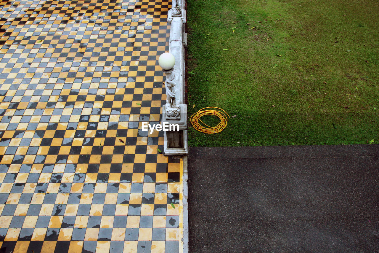 High angle view of wet footpath by grass