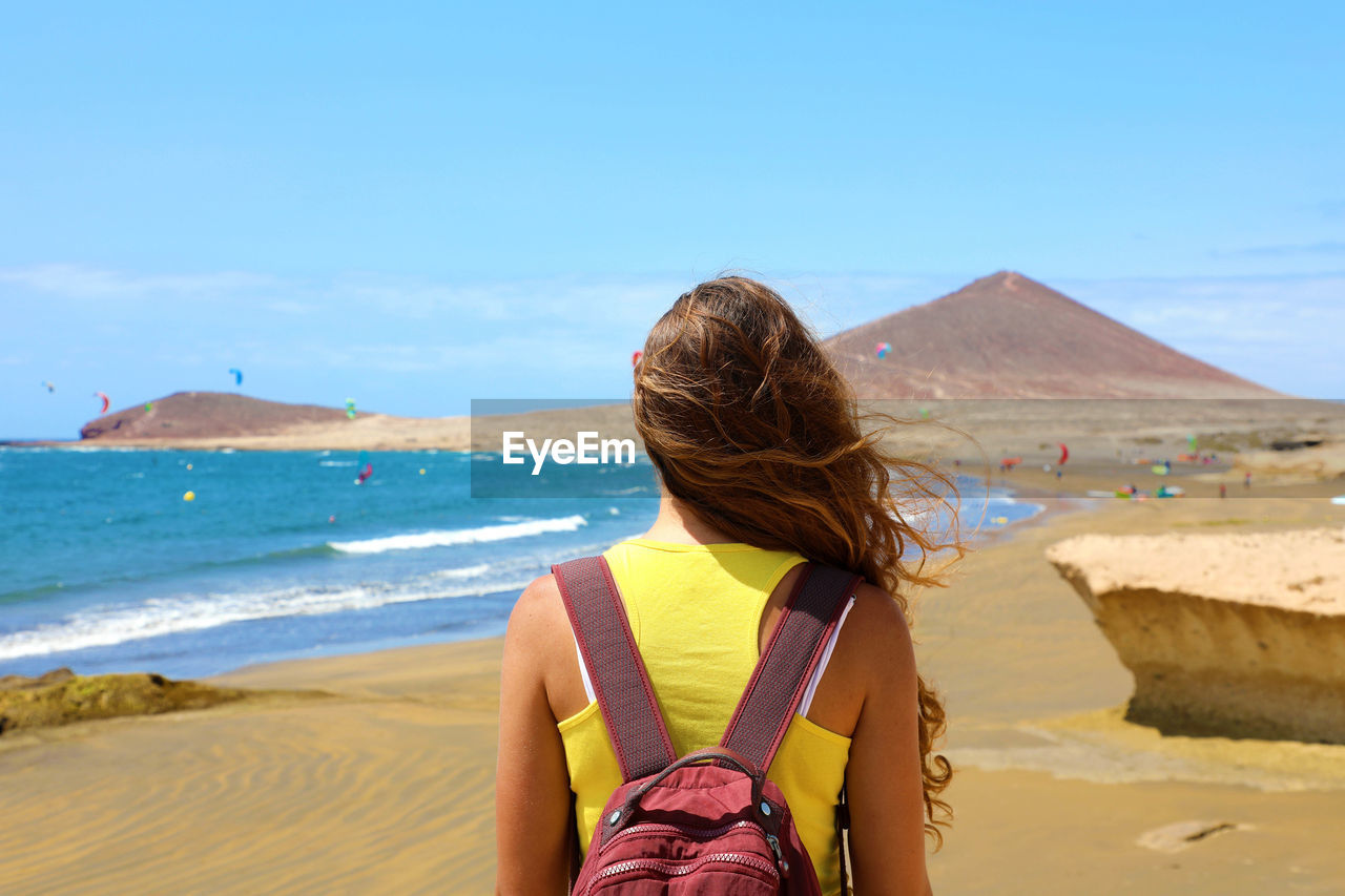 Rear view of woman looking at sea against sky