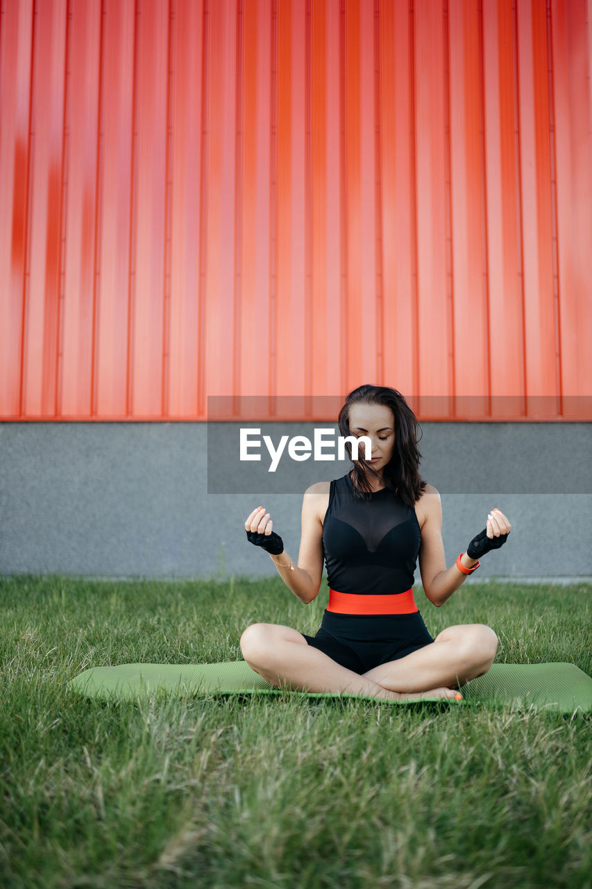 Young woman exercising on field