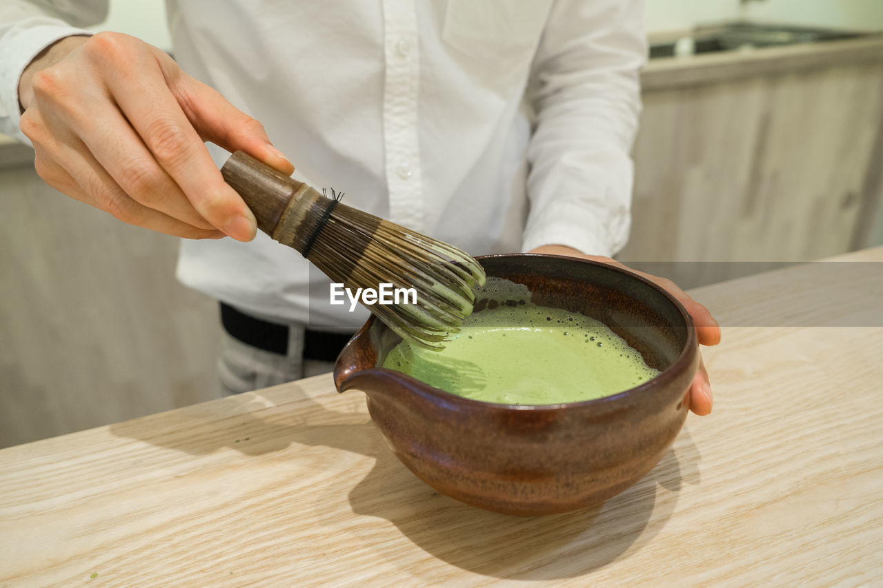 Midsection of man preparing food at table