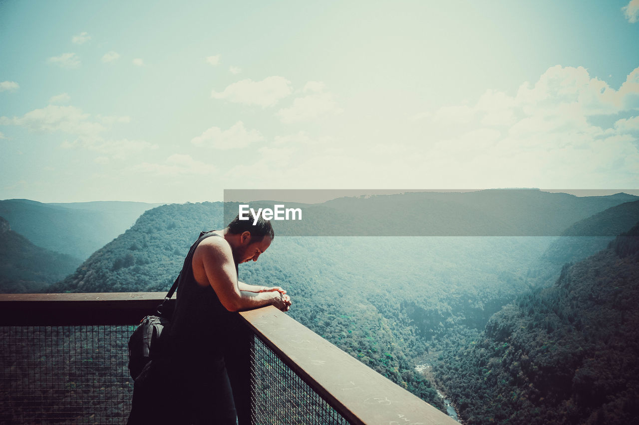 Man standing at observation point against mountain range