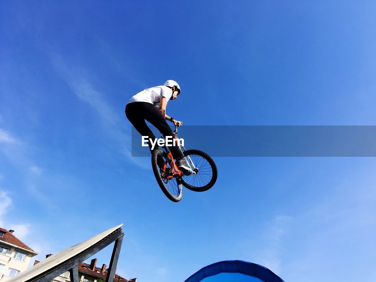 LOW ANGLE VIEW OF MAN JUMPING AGAINST SKY