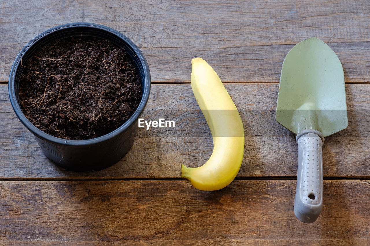 High angle view of pot  banana shovel on table