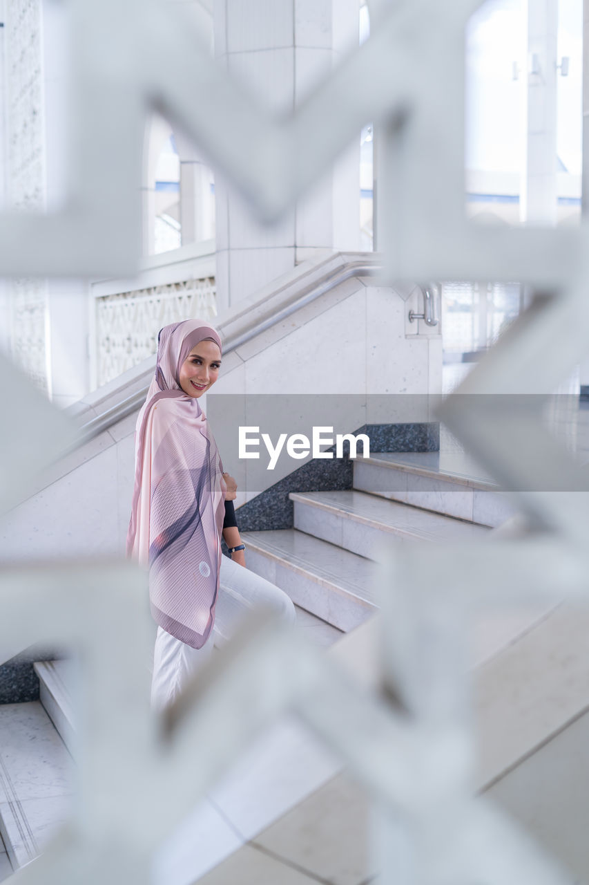 Portrait of woman wearing hijab seen through window