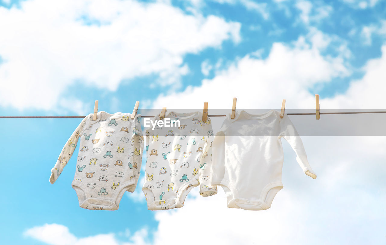 low angle view of clothes hanging on rope against sky