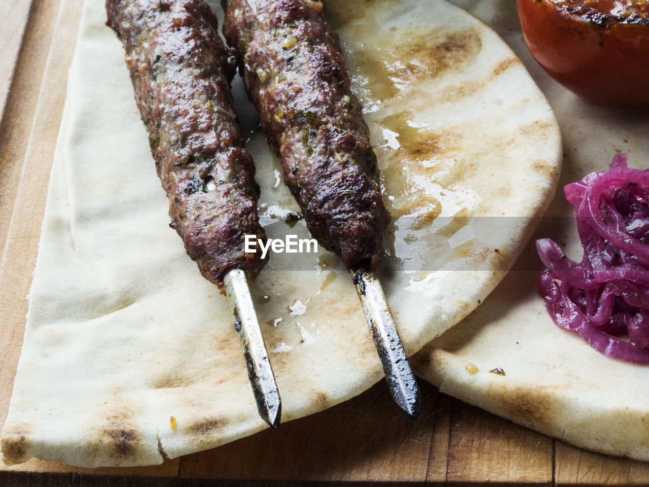 Close-up of fresh shish kebab lamb meat on skewers over cutting board