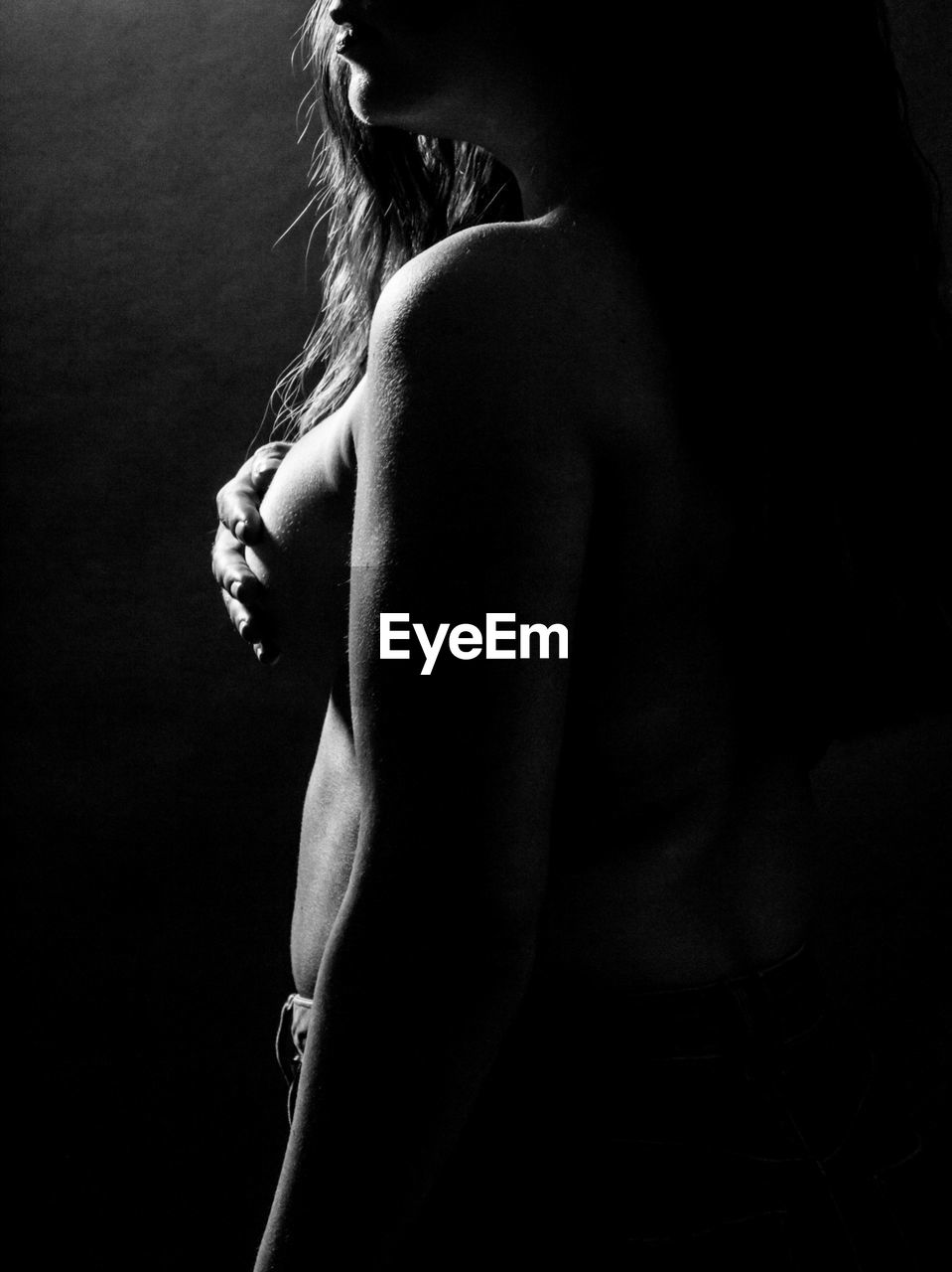 Naked woman standing in darkroom