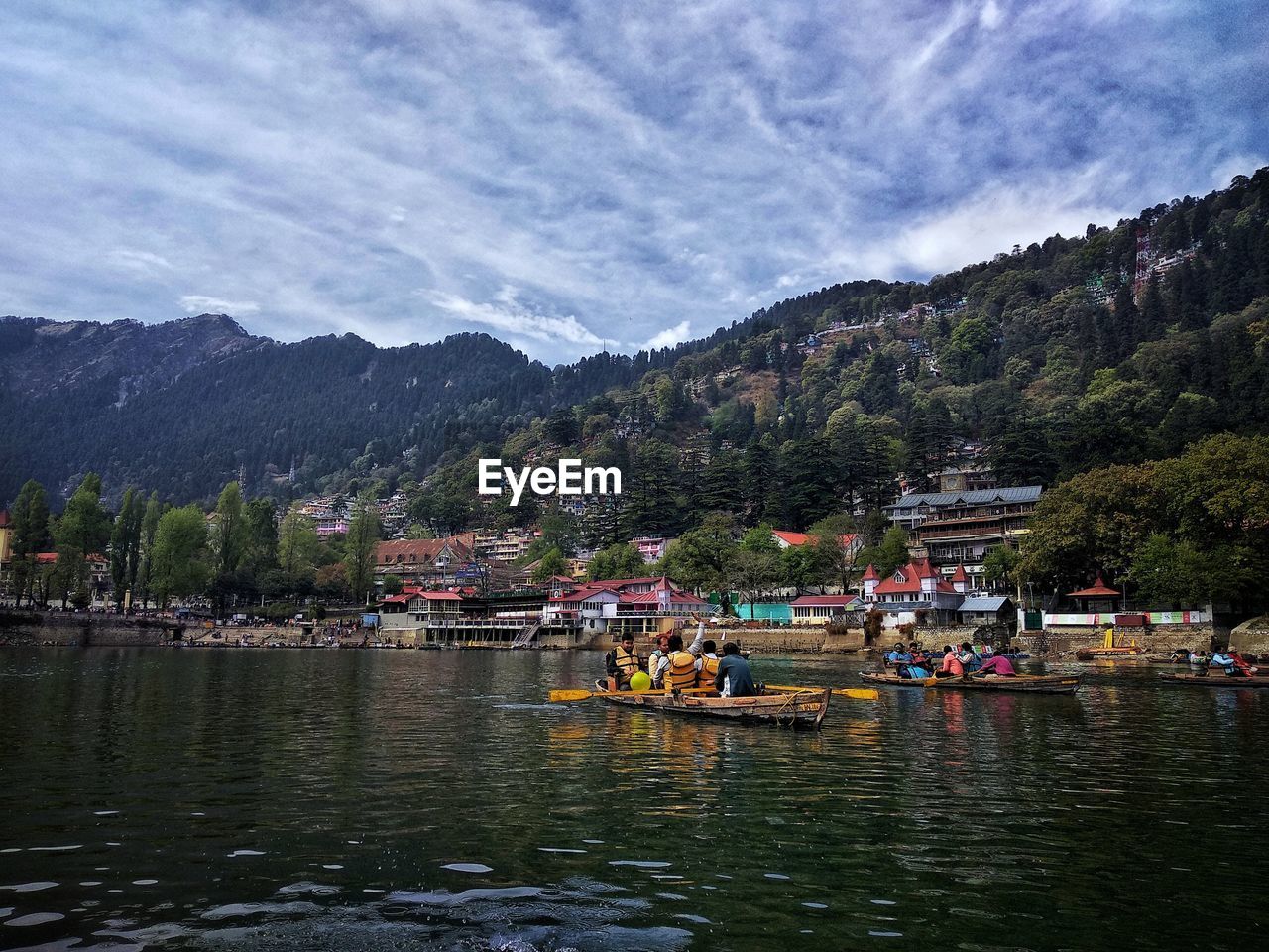 Boat on lake by mountains against sky