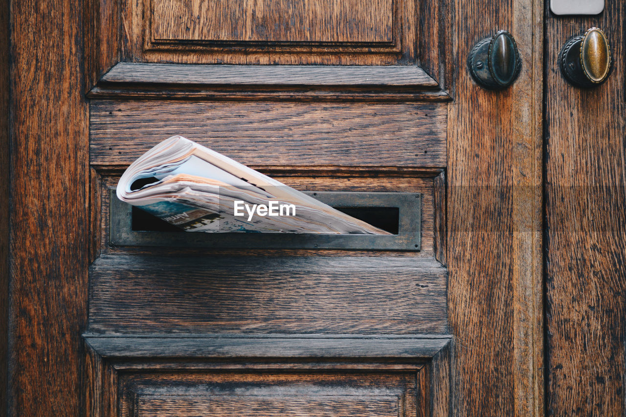 Close-up of newspaper in door