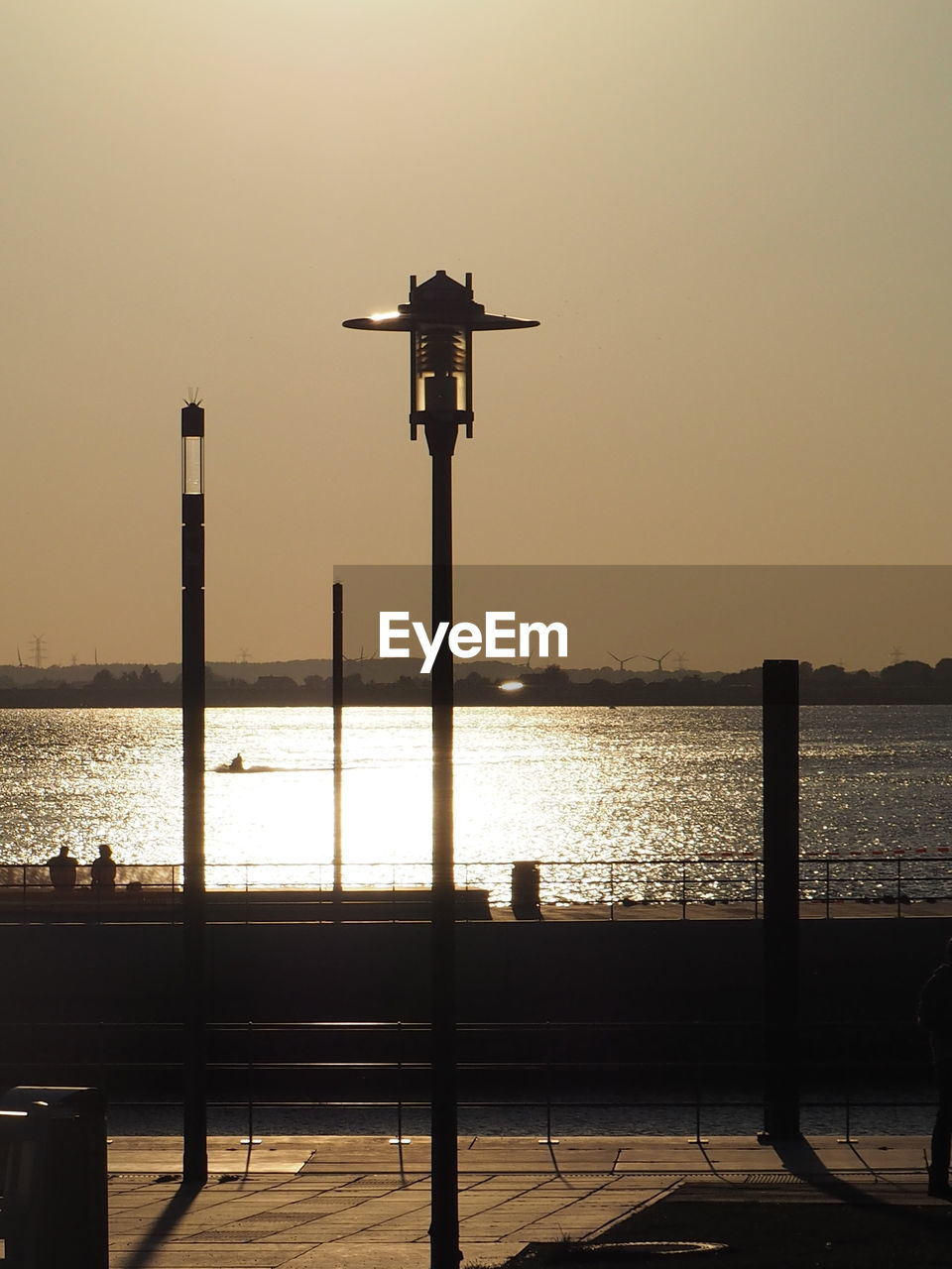 SILHOUETTE STREET LIGHT BY SEA AGAINST CLEAR SKY