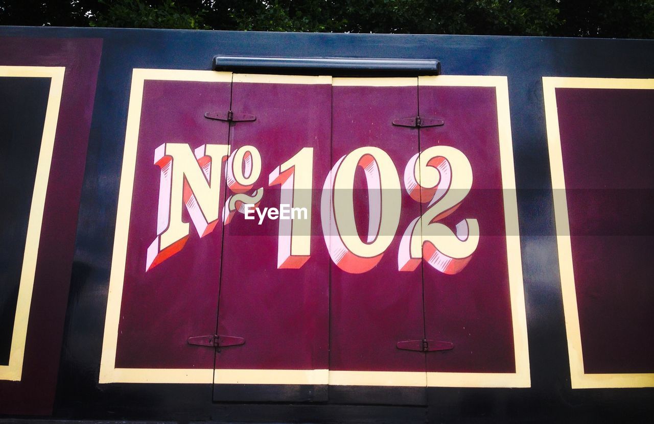 CLOSE-UP OF ILLUMINATED TEXT ON GLASS WINDOW AT NIGHT