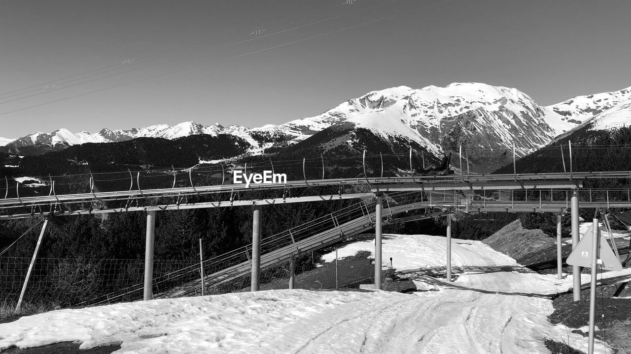 SNOW COVERED RAILING AGAINST MOUNTAIN RANGE