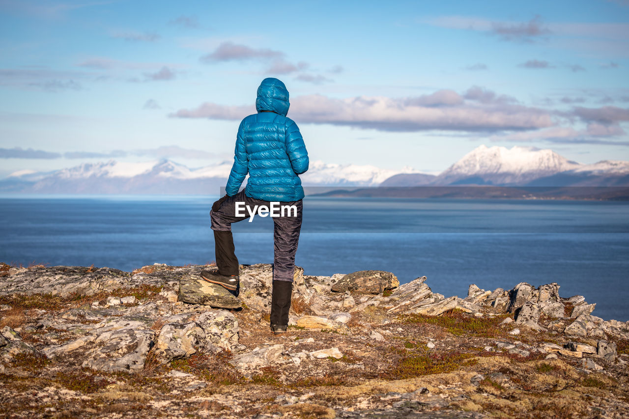 Rear view of person looking at sea against sky