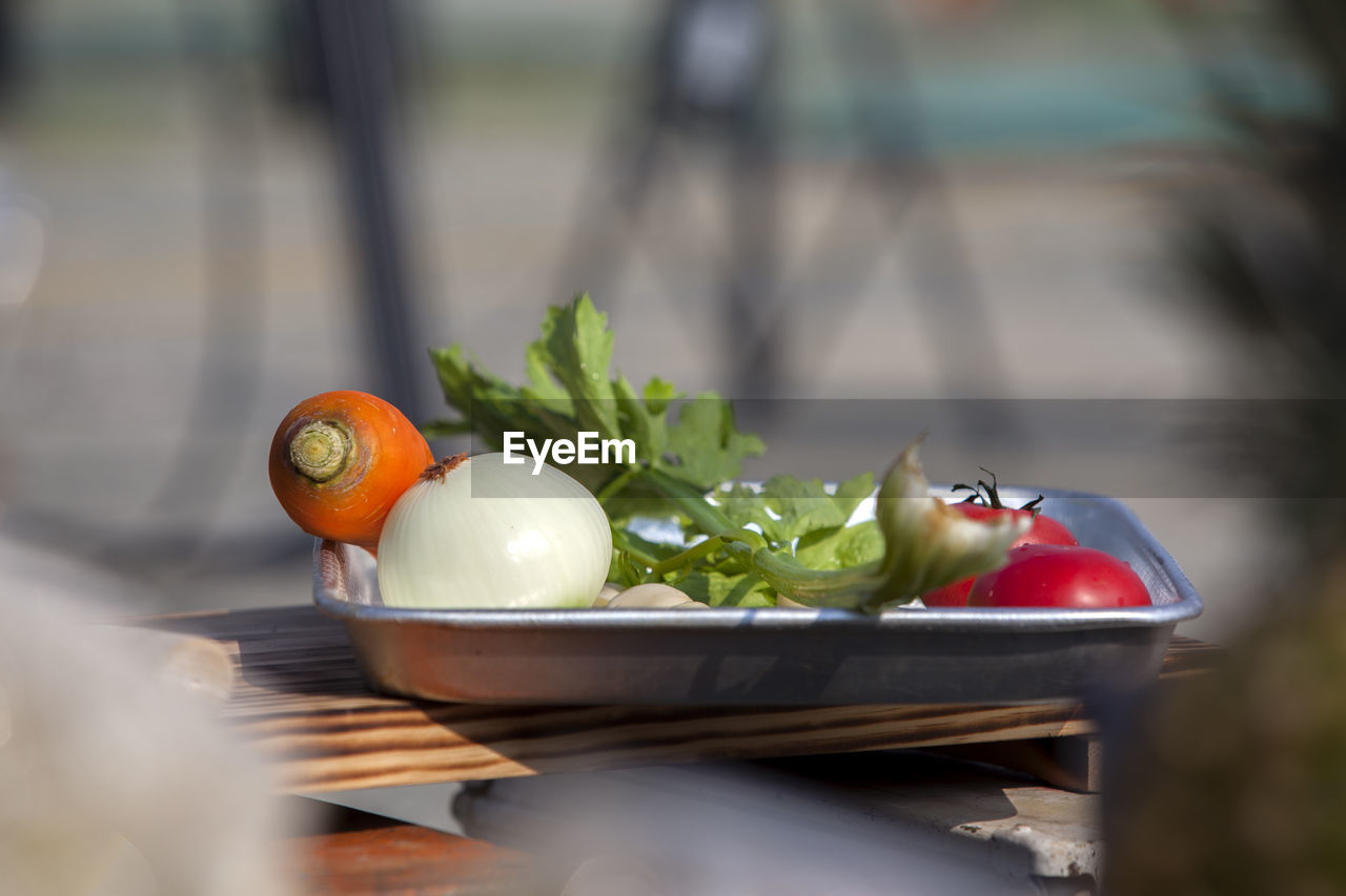 Close-up of vegetables in tray on cutting board