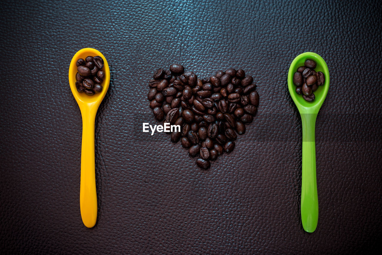 HIGH ANGLE VIEW OF COFFEE BEANS ON TABLE AGAINST WALL